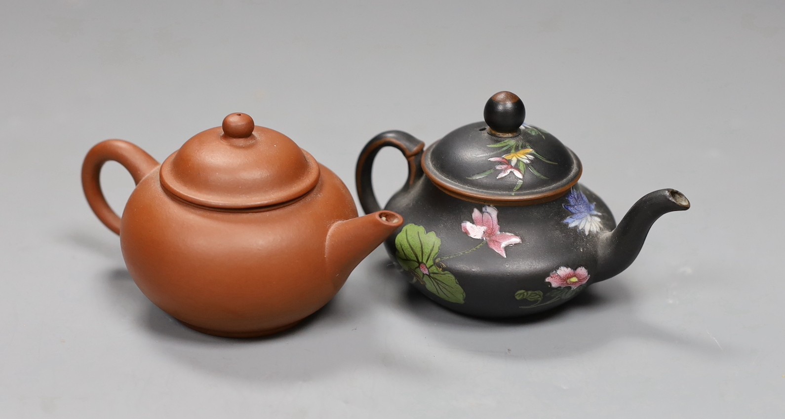 A Chinese Yixing miniature teapot and a Wedgwood enamelled black basalt miniature teapot, 6cm high